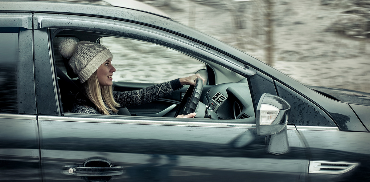 Woman smiling driving in winter - being a confident driver