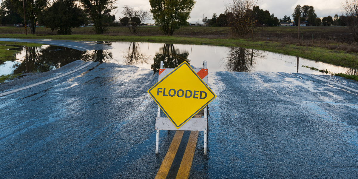 Photo of flooded road and flood warning sign