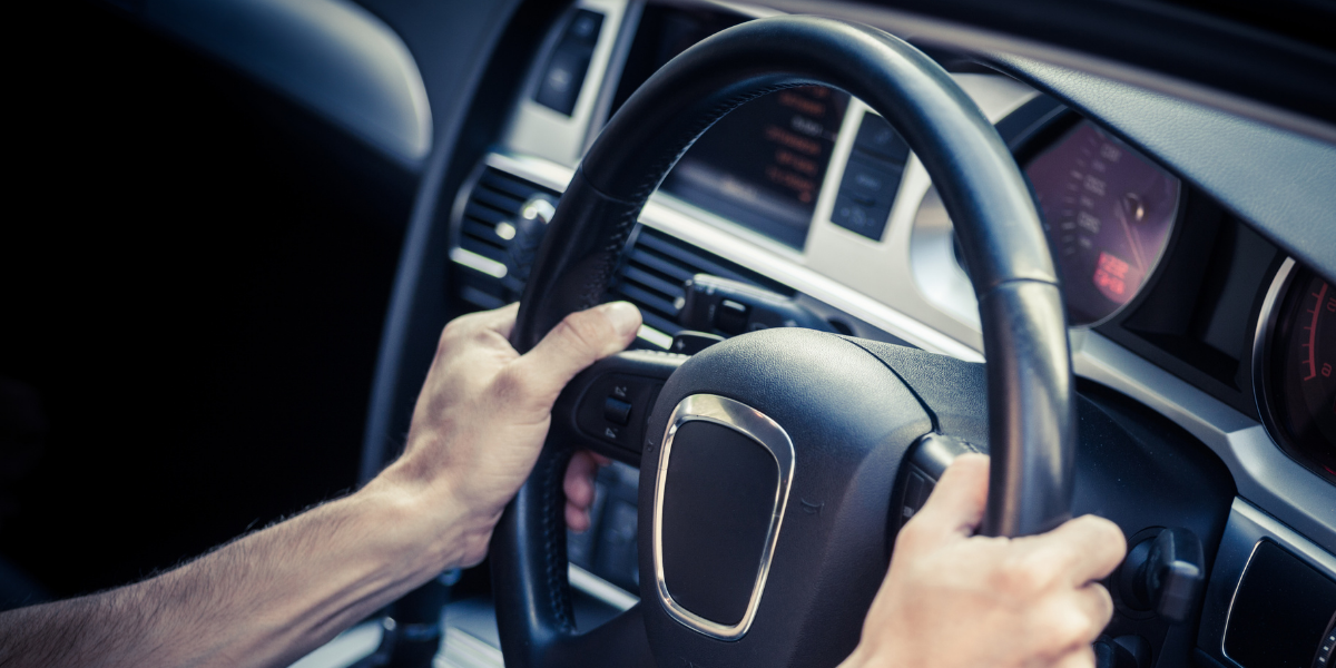 Photo of hands gripping a car steering wheel
