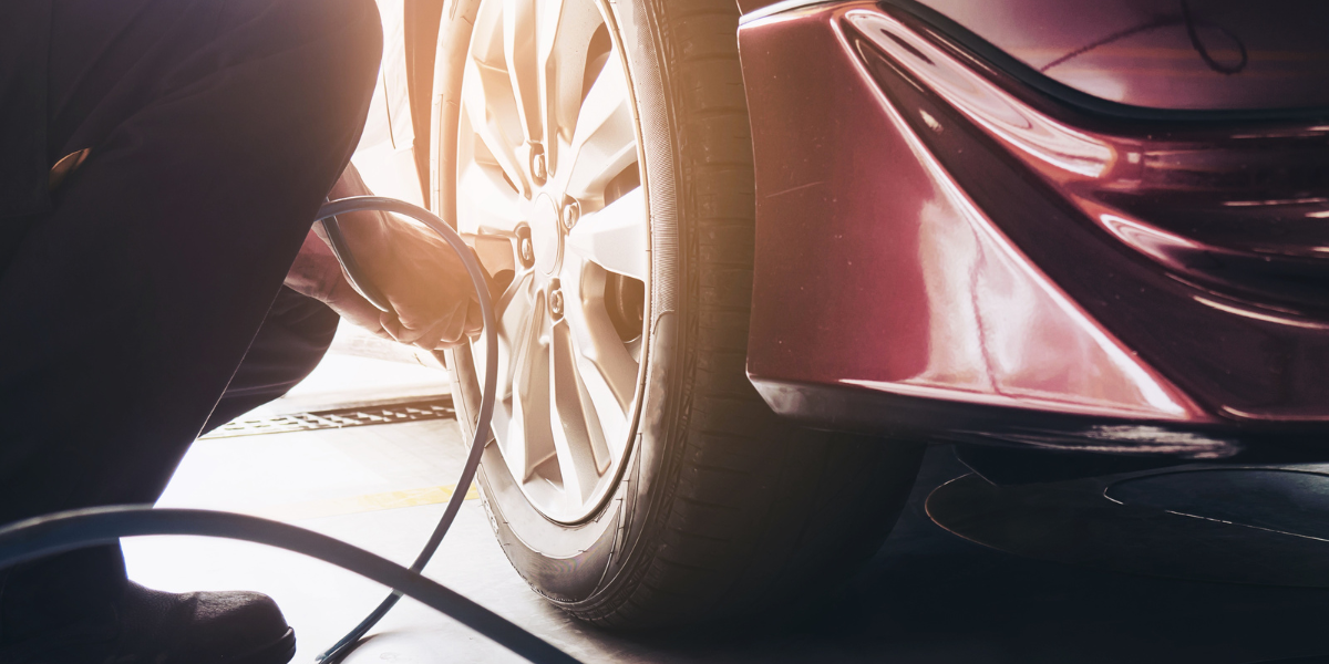 Photo of car tyre pressure being checked on a warm day